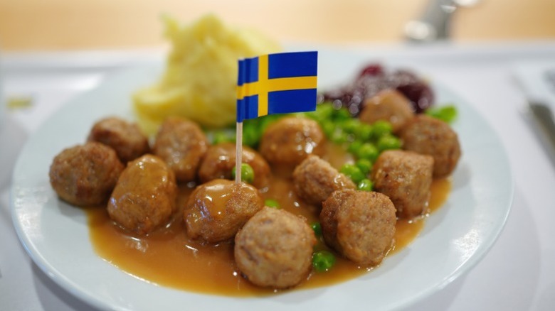 A plate of Swedish meatballs with a Swedish flag sticking out of one.