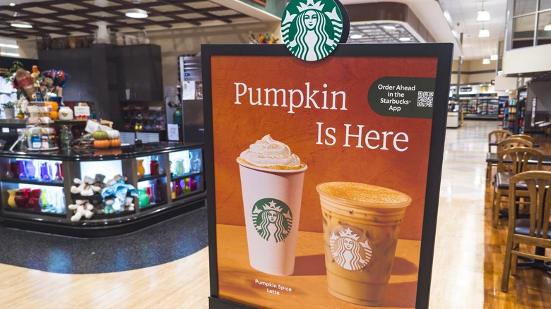 Sign reading "Pumpkin Is Here" in front of Starbucks location