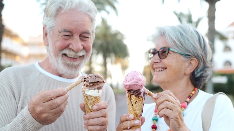 Man and woman smiling while enjoying ice cream cones