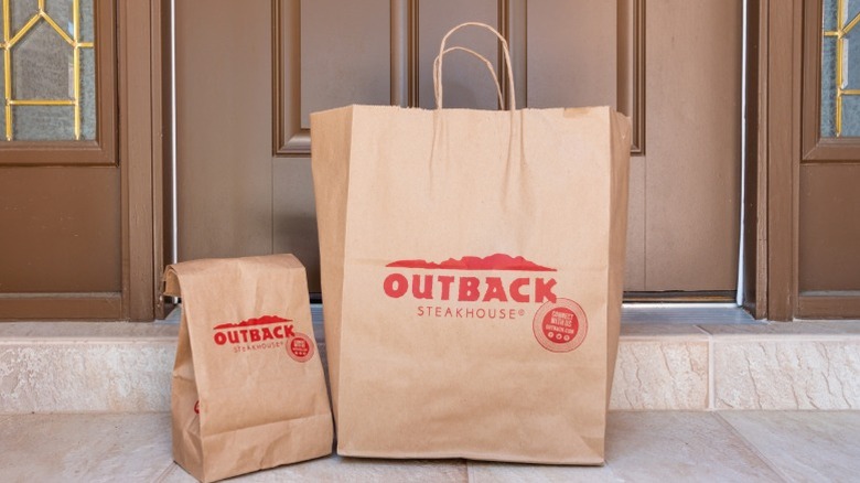 Outback Steakhouse delivery bags at someone's front door.