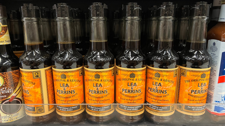 Worcestershire sauce being added to a tablespoon before being added to a pan.