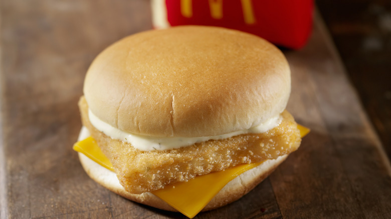 A closeup of a McDonald's Filet-O-Fish sandwich in front of an order of fries