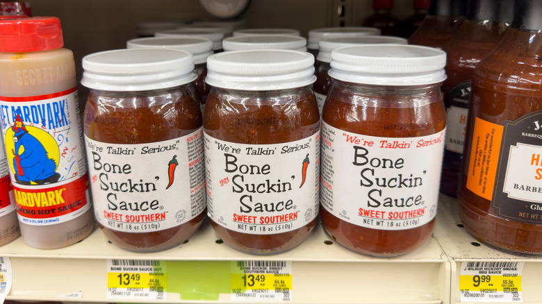 Bone Suckin' Sauce jars displayed on a grocery store shelf