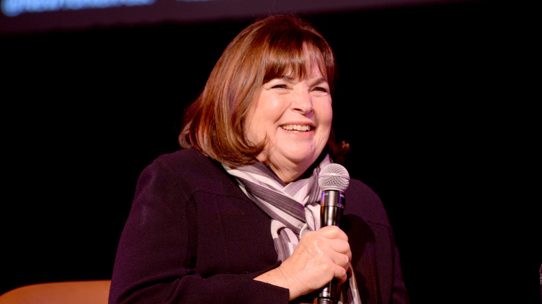 Ina Garten smiles on stage while holding a mic