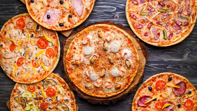 Top view of assorted cooked pizzas