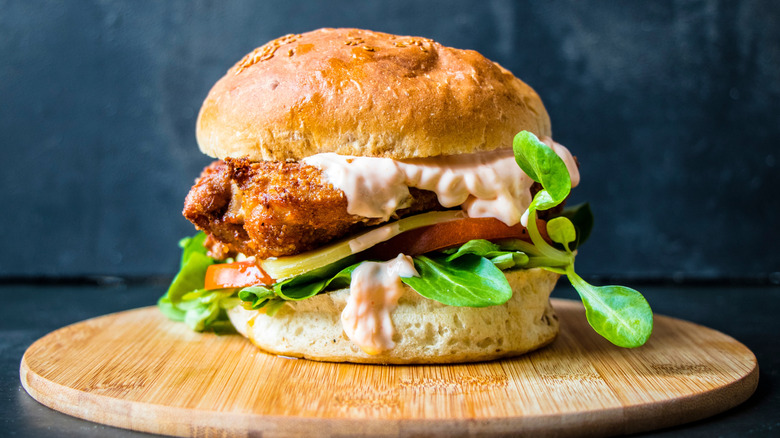 A fried chicken sandwich topped with sriracha mayo