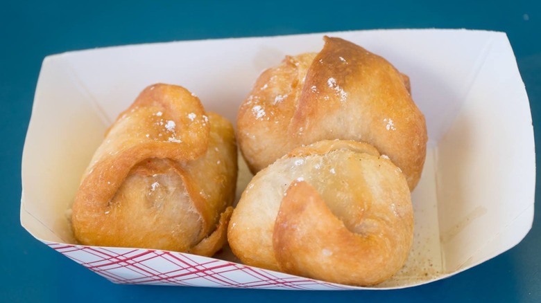Deep-fried butter in a cardboard tray on a blue table