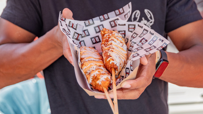 Man holds Destination Grille's lobster corn dog
