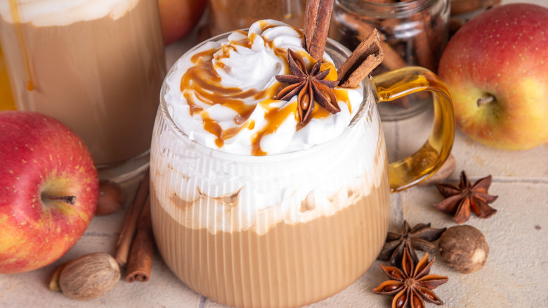 whipped cream topped coffee with caramel, whole spices, apples