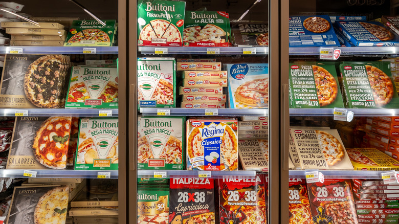 Shelves of frozen pizza in a grocery store display