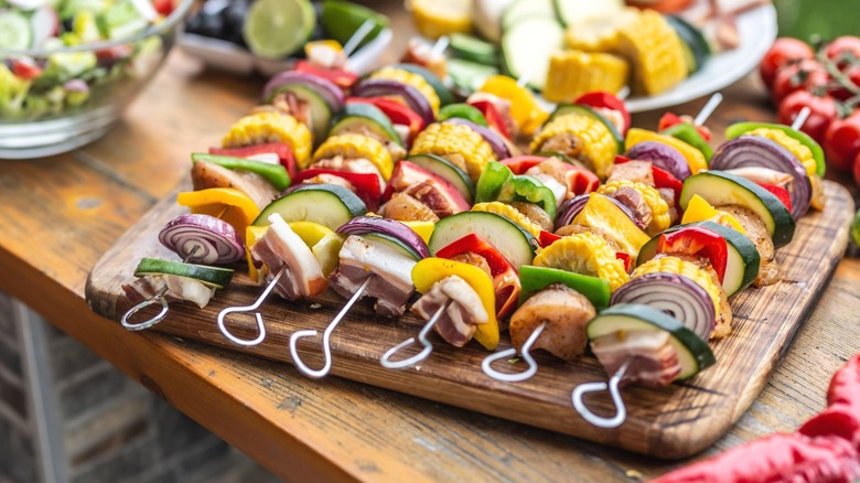 Meat and vegetable skewers on a wooden serving platter