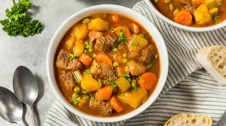 Beef stew with carrots and potatoes served in a white bowl.