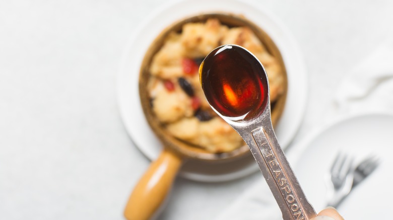 teaspoon of dark syrup over blurred dish