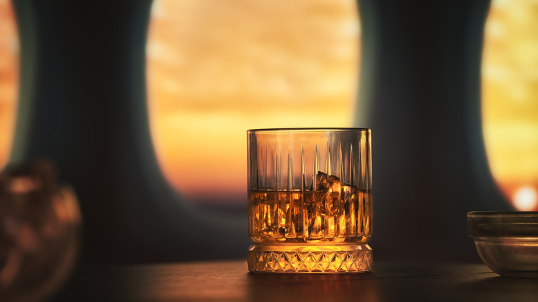 Whiskey glass in front of airplane windows