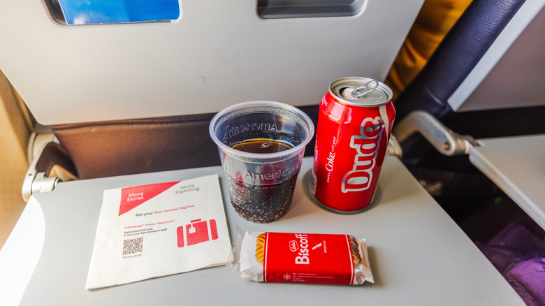 Biscoff cookie and Coca-Cola can on airplane tray