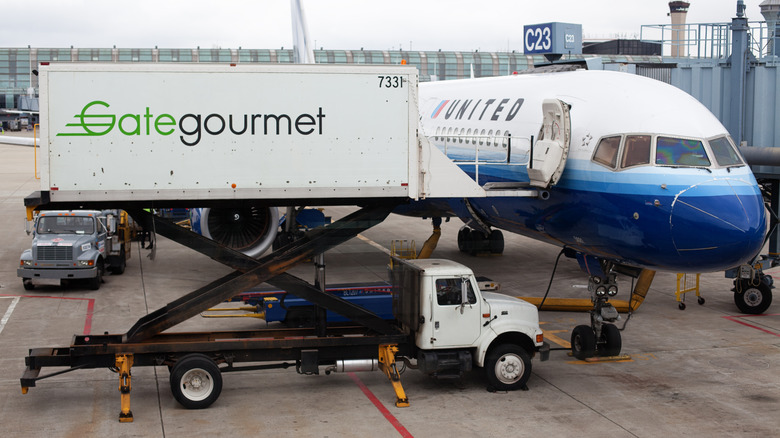 Food trailer next to United airplane