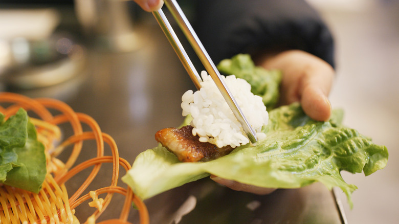 placing rice in lettuce wrap