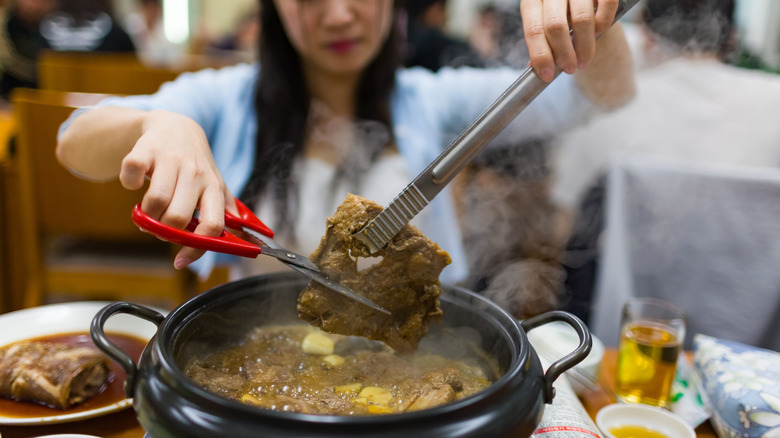 woman cutting meat with scissors