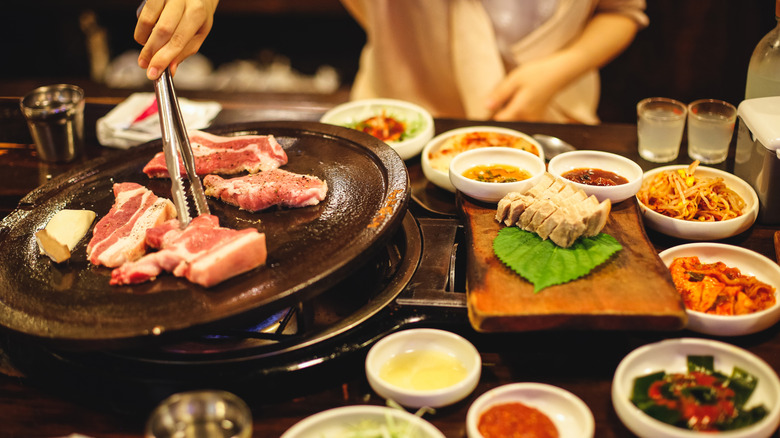 cooking Korean barbecue at table
