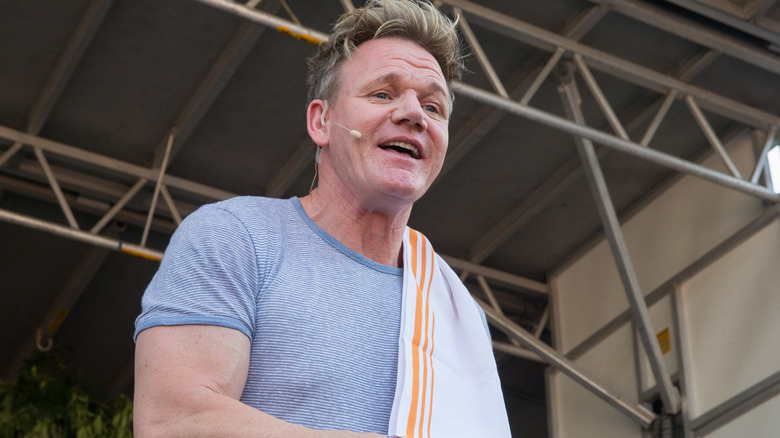 Gordon Ramsay on a stage mixing something in a bowl