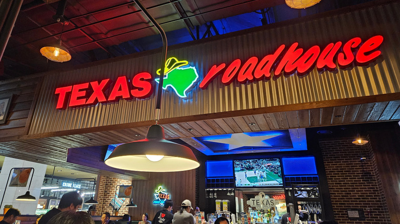 The interior of a Texas Roadhouse with the brand name on the wall.