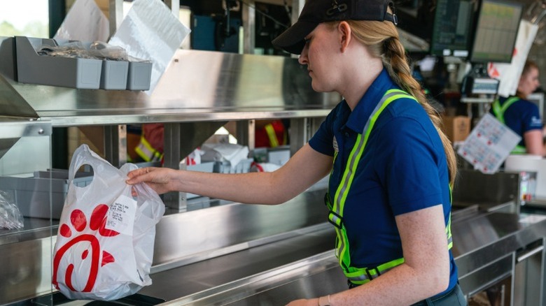 An employee prepares a to-go order at Chick-Fil-A