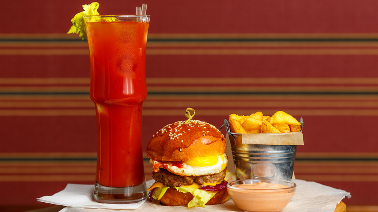 Bloody mary next to a burger and fries