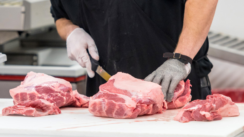 A butcher portions meat into sections