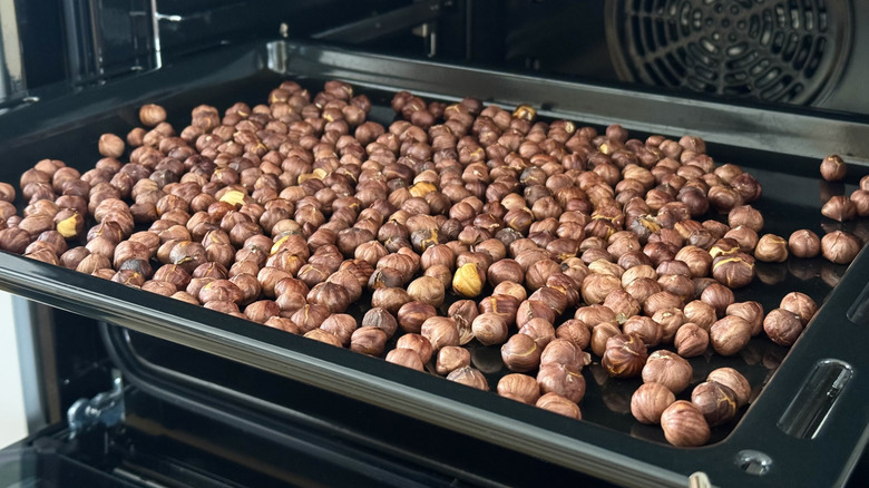 Close-up golden-brown whole hazelnuts baked in the oven.