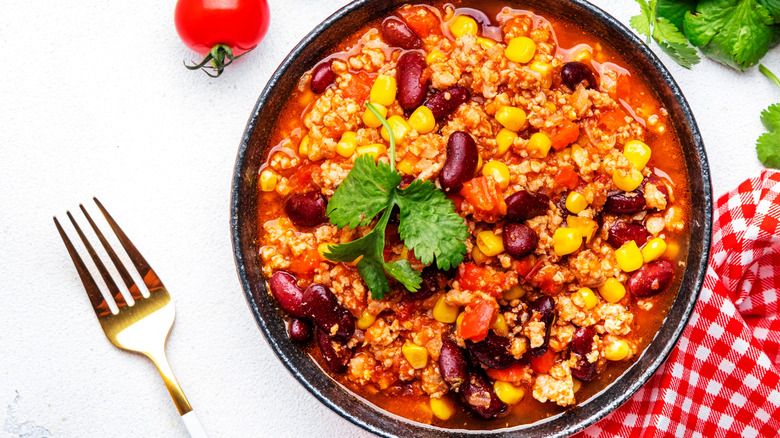 Bowl of minced beef, red beans, paprika, corn and hot peppers in spicy tomato sauce