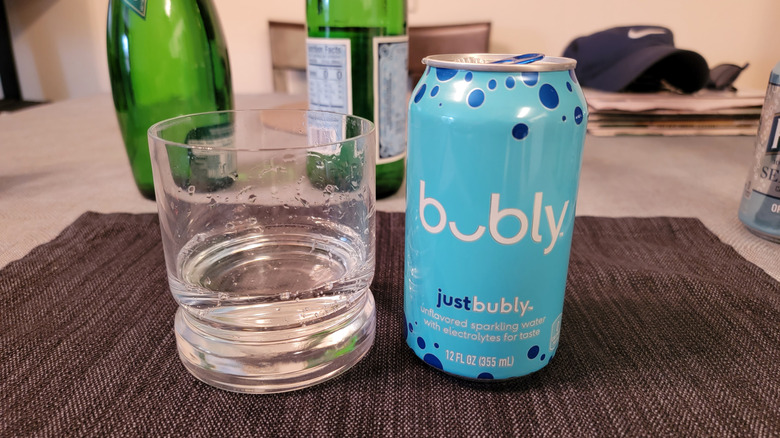 Can of blue Bubly next to drinking glass