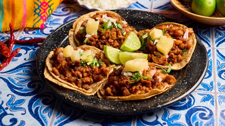 al pastor tacos with pineapple, lime, and corn tortilla