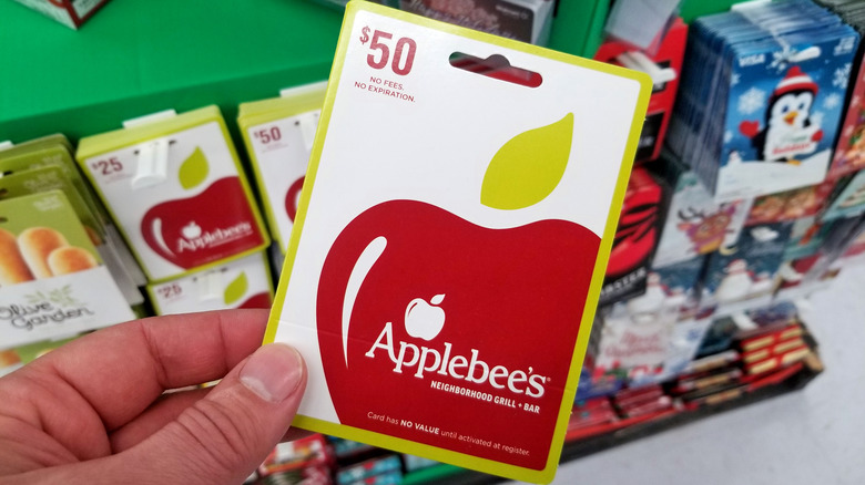 A hand holding an Applebee's gift card