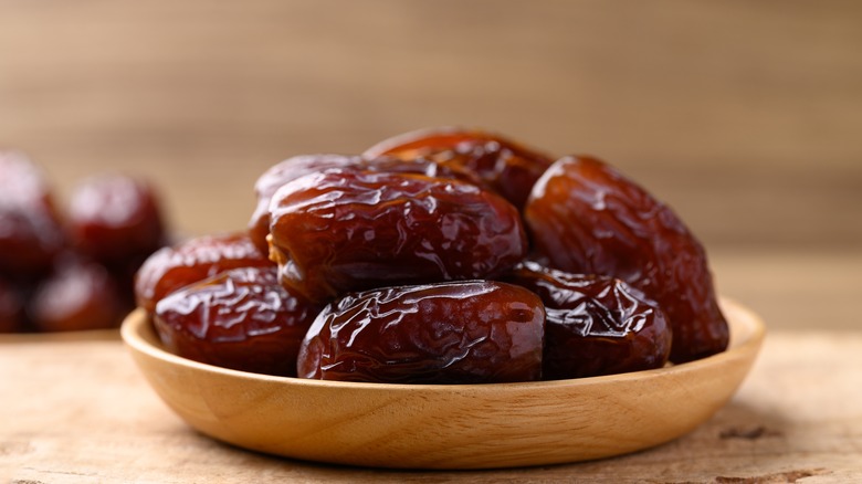 Medjool dates in a wooden bowl.