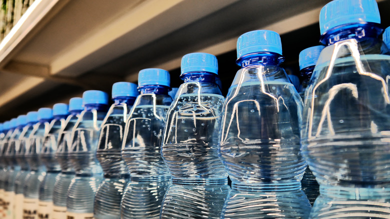 Potable water bottled lined up on a supermarket shelf.