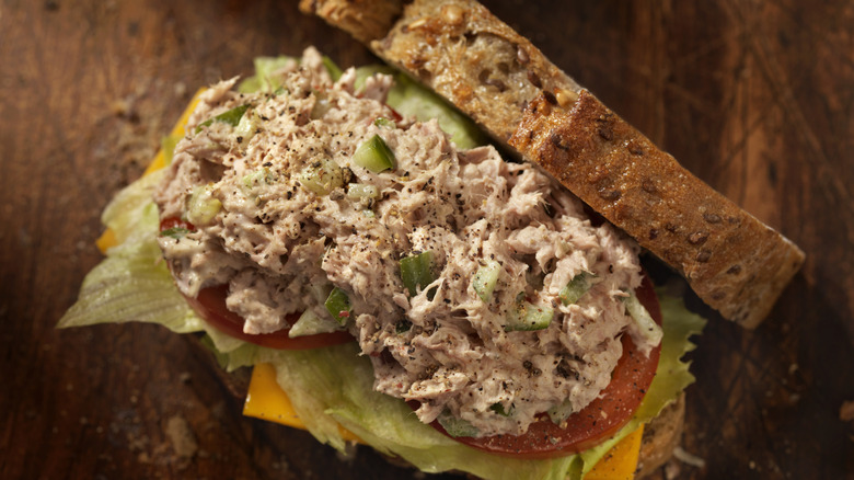 Tuna salad on bread with tomato, cheese, and lettuce