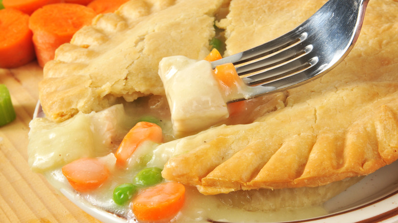 Fork scooping chicken from pot pie