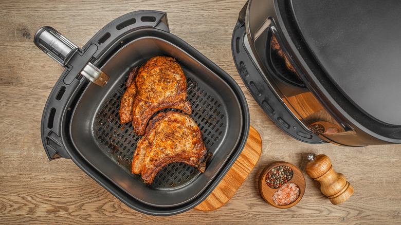 Top view of air fryer basket with browned pork chops