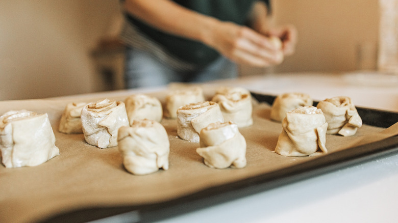 person shaping cinnamon rolls