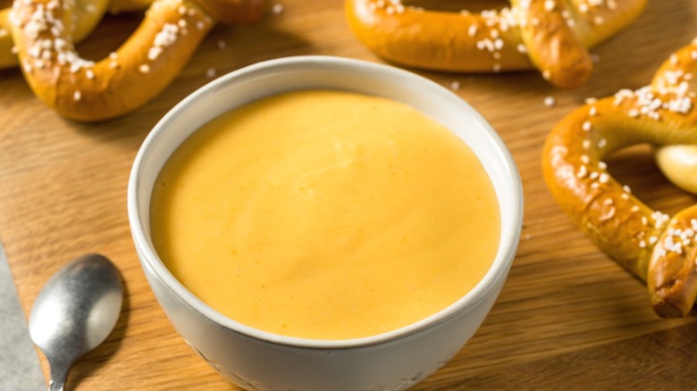 A beer cheese dip bowl with pretzels.