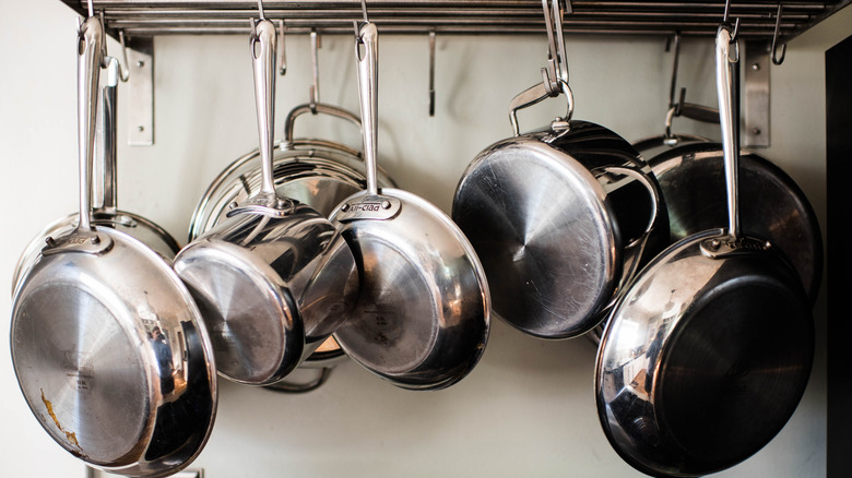 Assorted pots and pans hanging from a rack