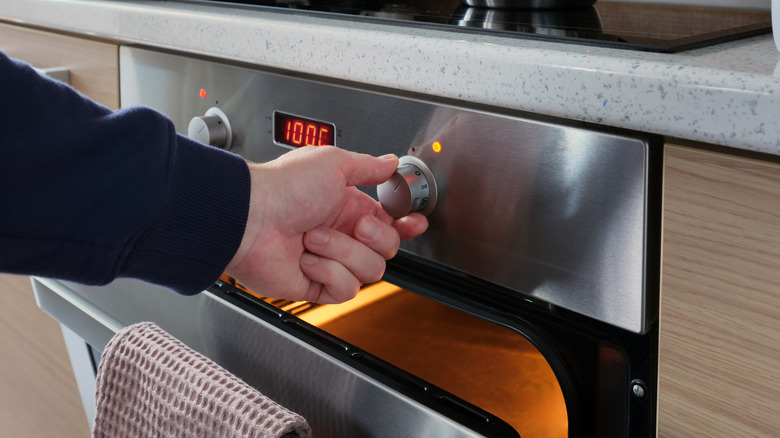 Hand adjusting oven setting