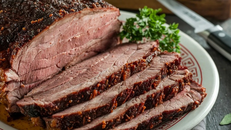 Sliced smoked brisket on a white plate