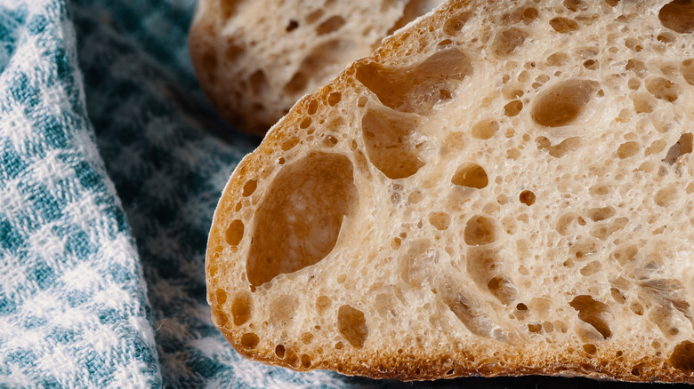 A slice of sourdough sitting on top of a tea towel