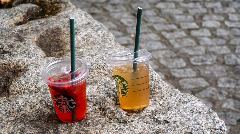 Two Starbucks lemonade drinks on a rock, raspberry and iced tea