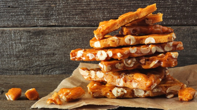 A stack of peanut brittle against a rustic wooden background.