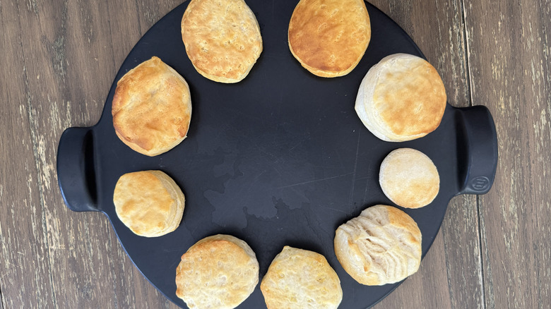 Nine cooked canned biscuits in round black tray