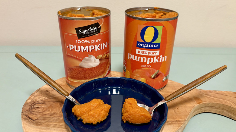 Cans and spoonfuls of Signature Select and O Organics pure pumpkin
