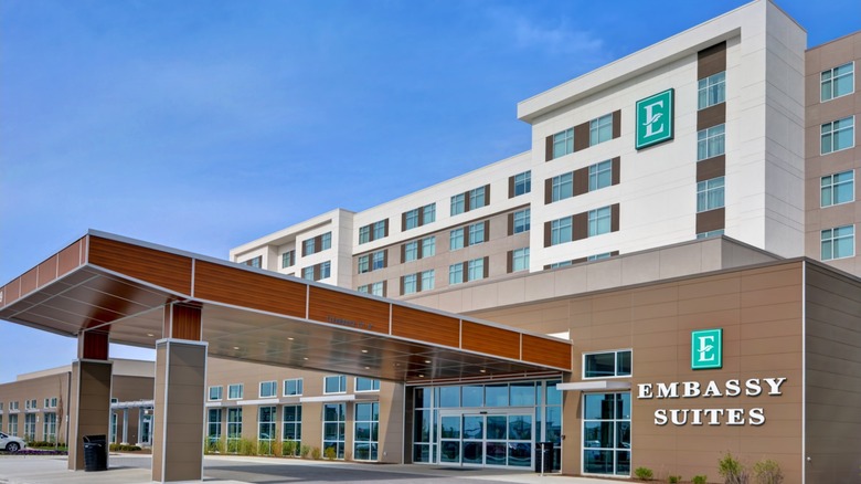 An multi-story Embassy Suites with a carport in front.