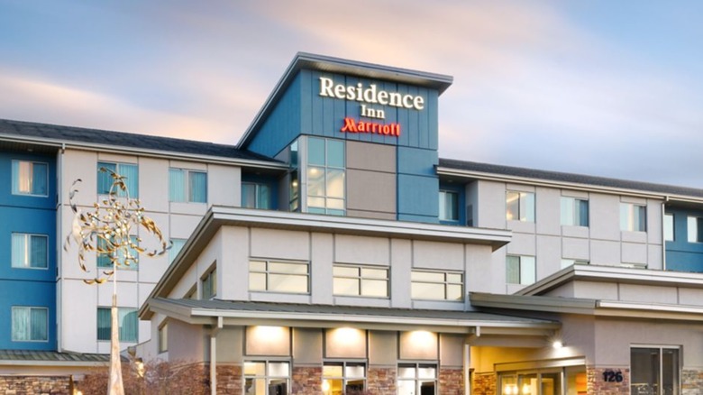 A Residence Inn with gray and blue siding and stone accents.